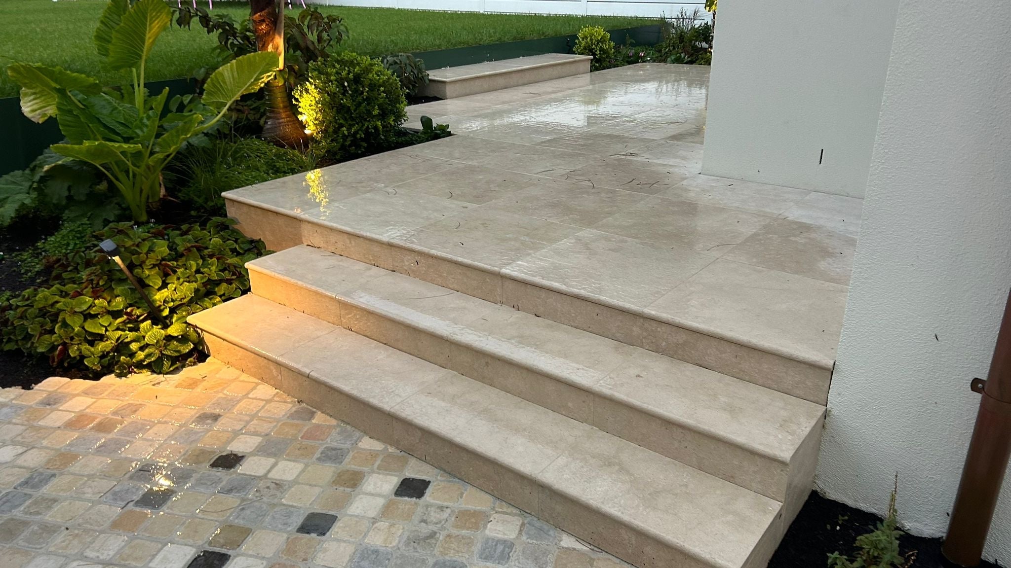 Sealed marble staircase and outdoor terrace with garden lighting at a prestige residence